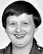 Headshot of a woman with short, dark hair, smiling into the camera.