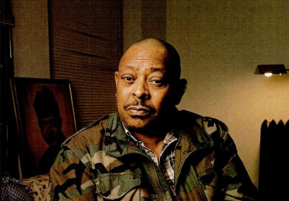 An African American Veteran wearing a fatigue jacket.