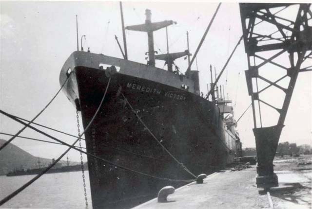A large ship is tied up at a dock.