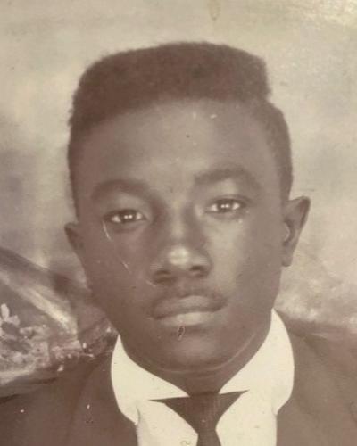 A young African-American man looks directly into the camera. He is wearing a jacket and tie.