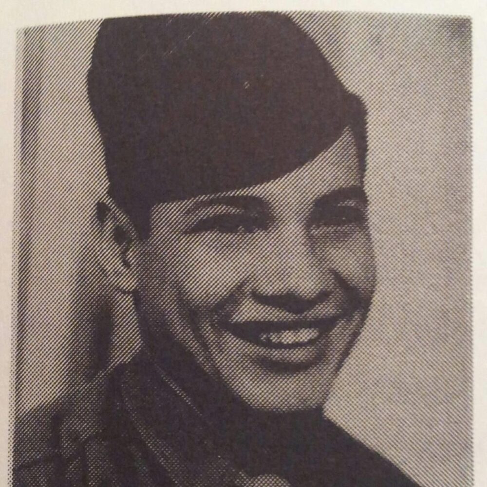 A young man, smiling in his Army uniform and cap.