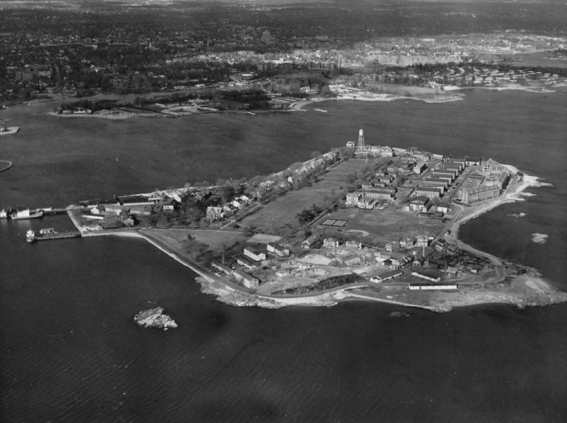 An aerial black and white photograph of a small island with a military compound.
