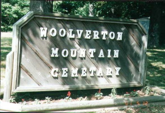 A wooden sign reads, “Woolverton Mountain Cemetery.”