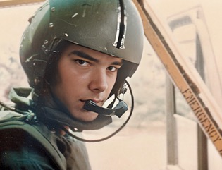 A young man wearing a flak jacket and helmet.