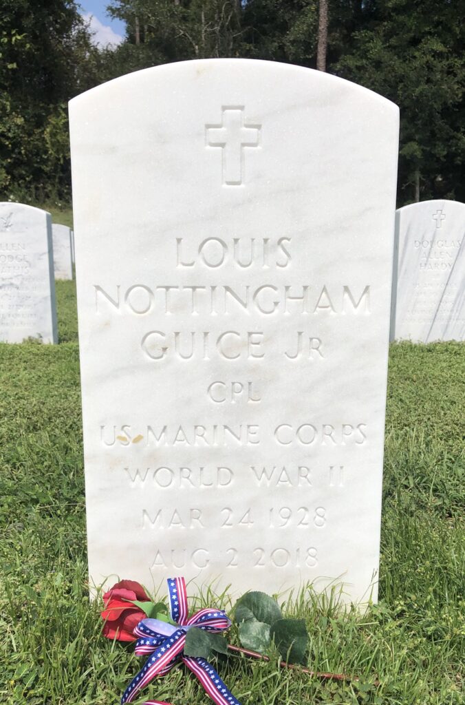 A white marble-arched grave is inscribed with: “Louis Nottinham Guice Jr. CPL U.S. Marine Corps World War II Mar 24 1928 Aug 2 2018.”