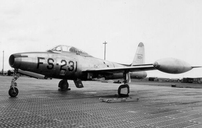A black and white image of a side view of a small plane. 