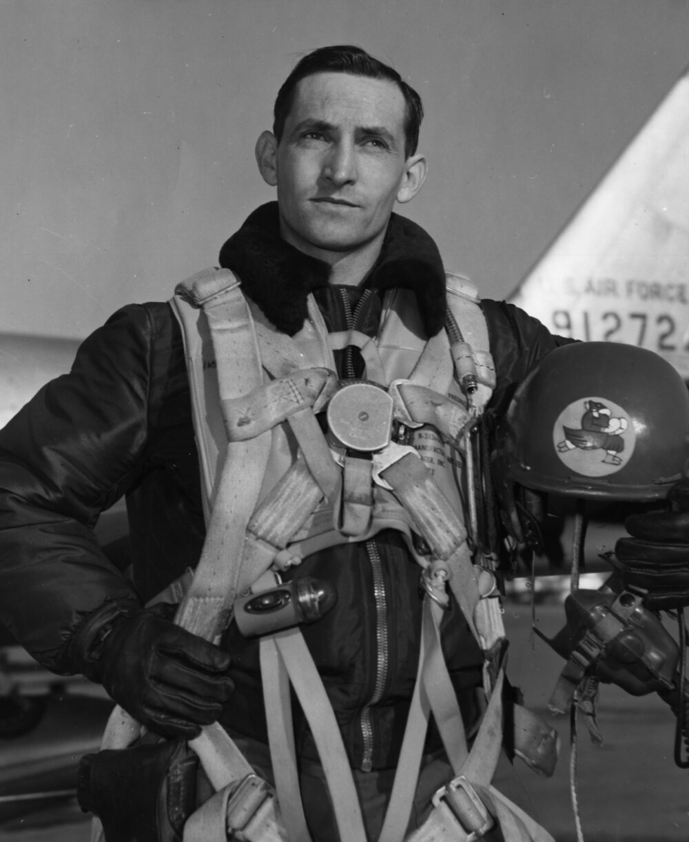 George Davis in his flight suit standing in front of an Air Force jet.