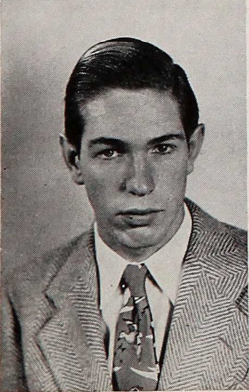 A black and white headshot of a young White man in a suit and tie. He is looking directly at the camera. 