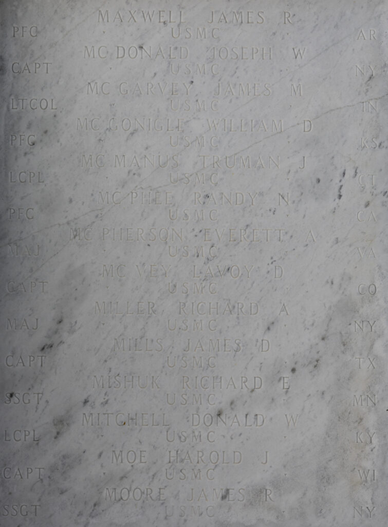 A photo of a white marble walls with several names engraved, including Mills.