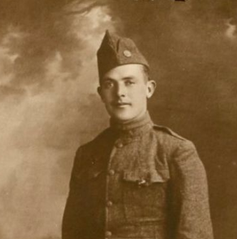 A young man in a World War I uniform looking at the camera.
