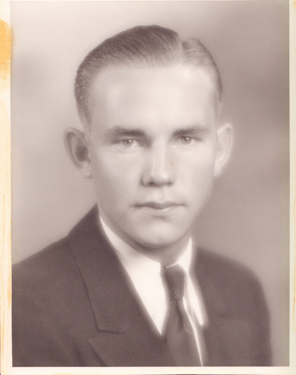 Photograph of a young man in a jacket and tie.