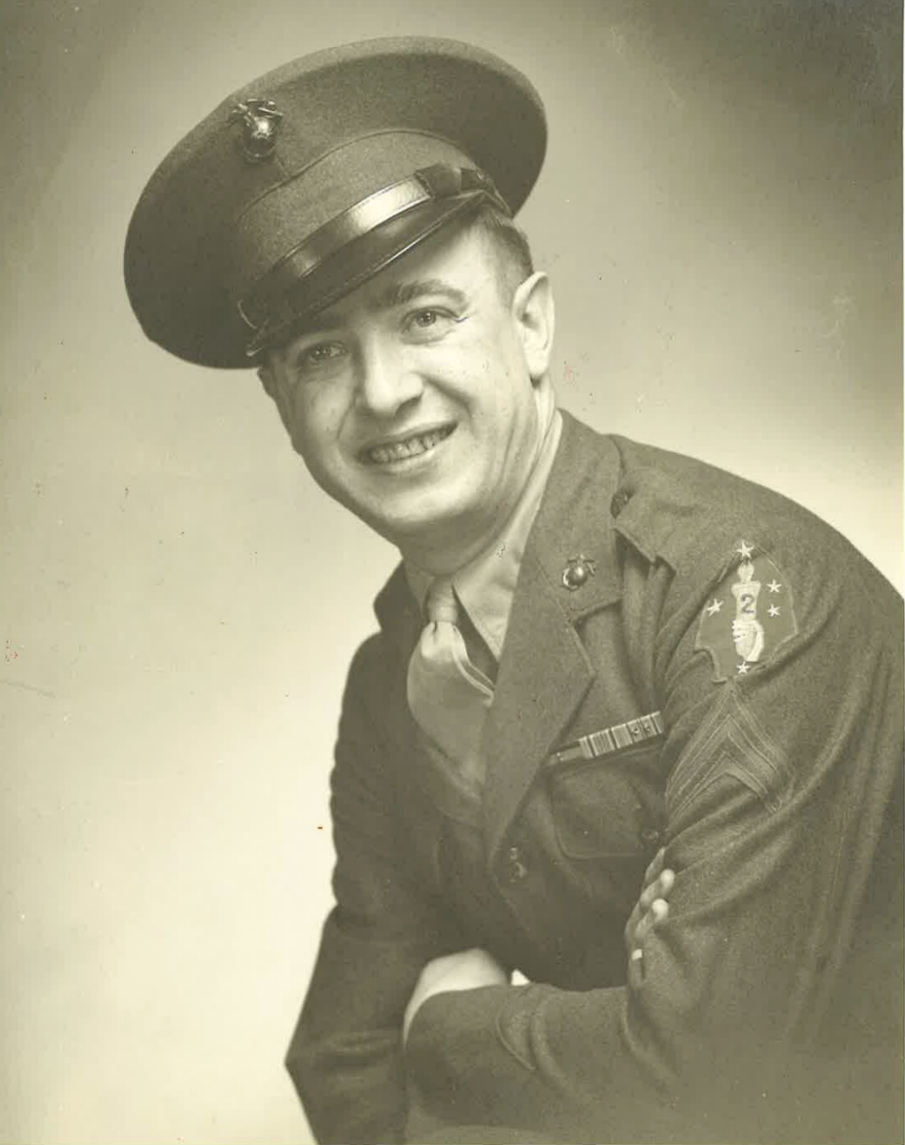 A young man in a Marine Corps uniform smiling.