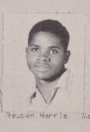 An African American teenage boy in a white dress shirt.