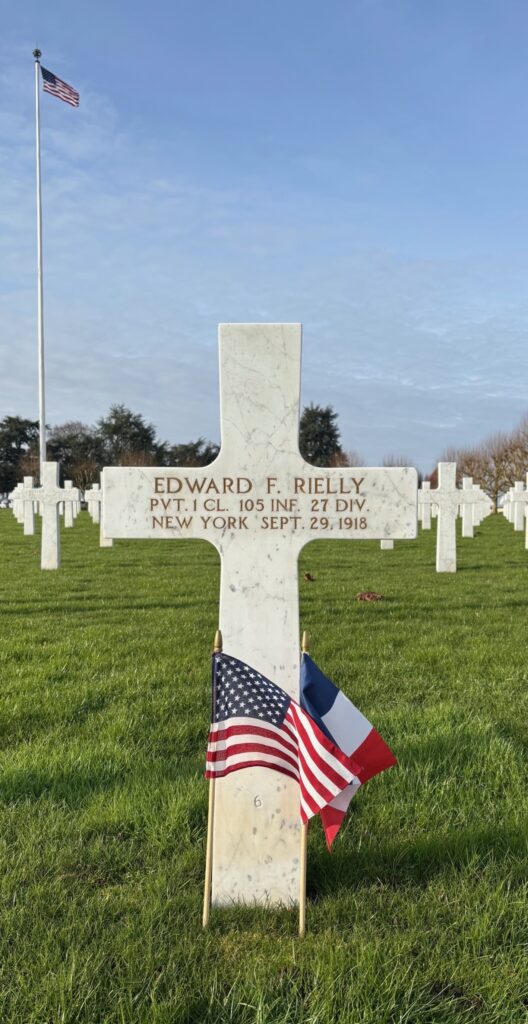 A color image of a white marble cross headstone that says, “Edward F. Reilly PVT. 1 CL 105 INF 27 DIV. New York Sept. 29, 1918”