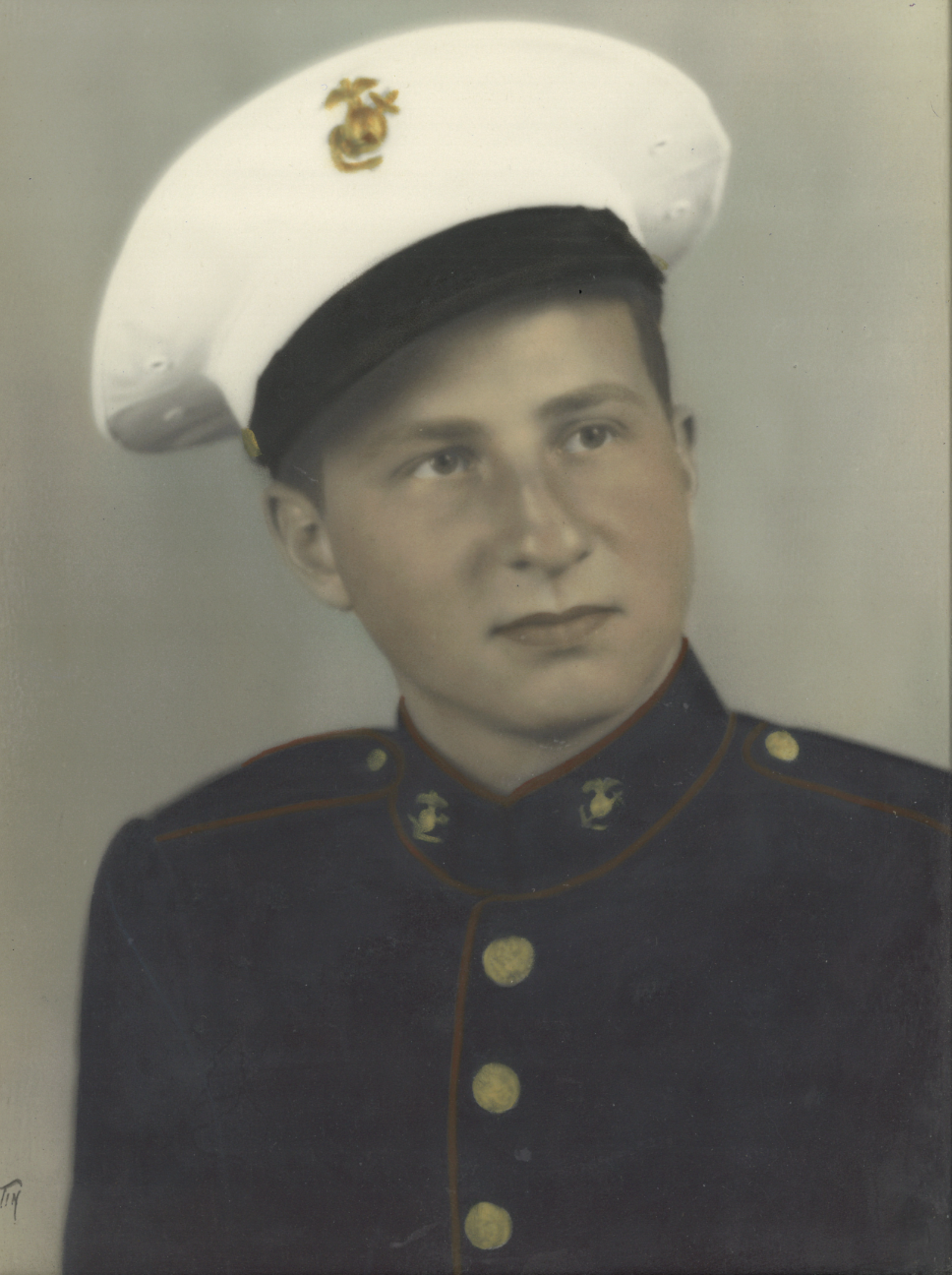 A young man in a Marine Corps uniform and hat.