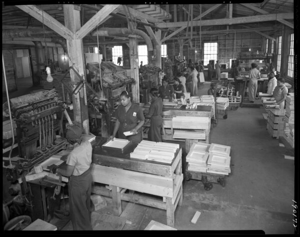 A black and white image of several Black women working in a factory.
