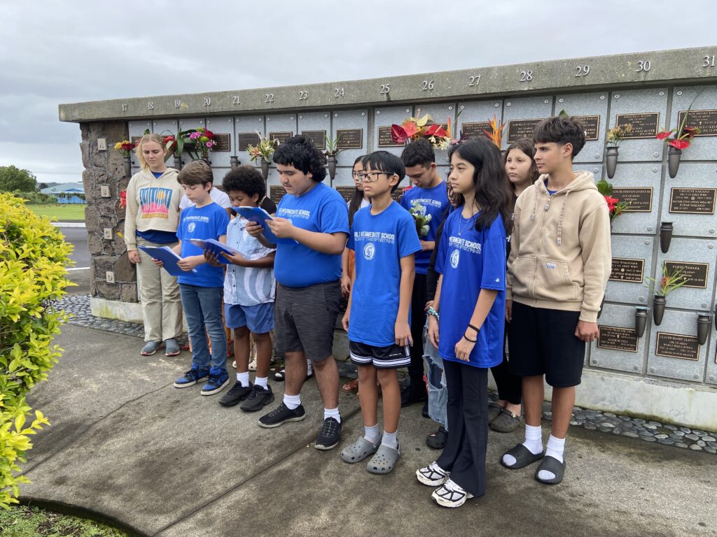 A color photograph of students standing in front of a Columbarium.