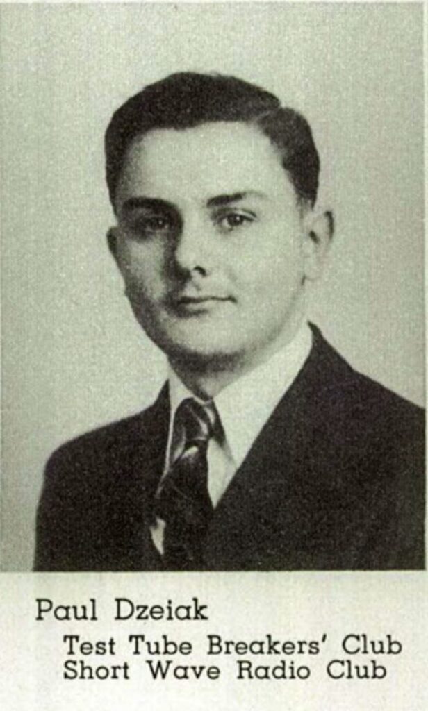 A black and white headshot of a young White man in a suit and tie. Underneath the image it states, “Paul Dzeiak Test Tube Breakers’ Club Short Wave Radio Club.”