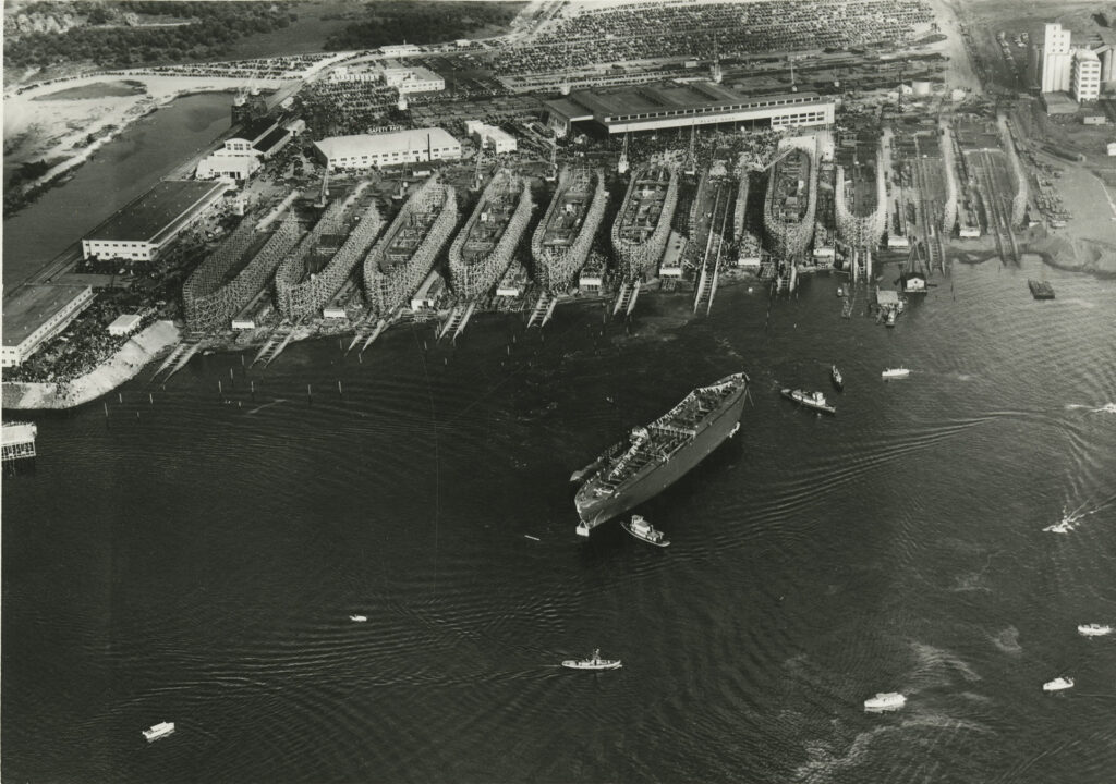 A black and white aerial image of several ships in port.