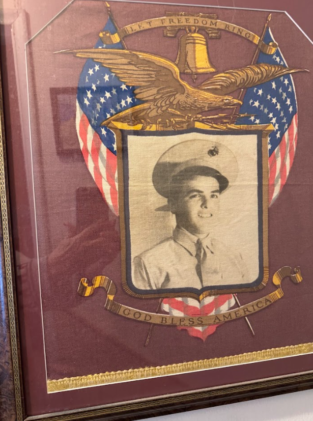 A framed photo of a young man in uniform surrounded by flags.