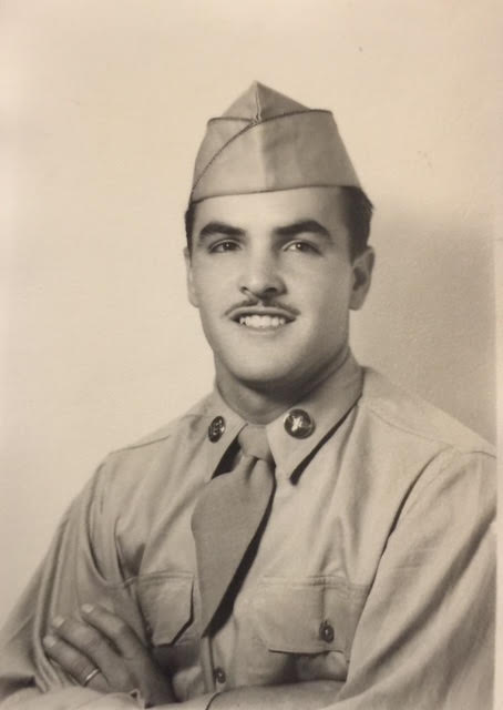 A black and white headshot of a young Hispanic man in uniform.