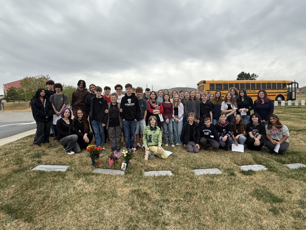 A color image of a large group of people at a cemetery.