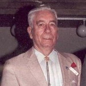 A color headshot photo of an older White man in a suit and tie.