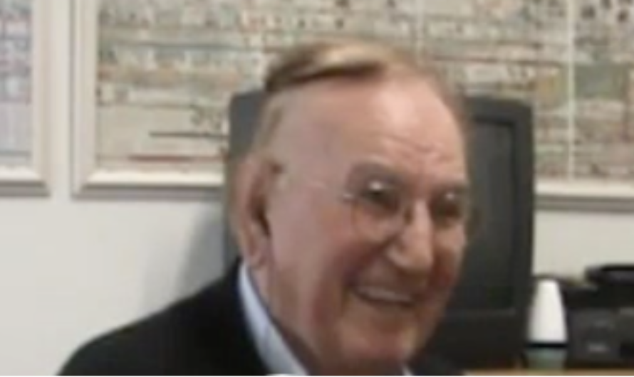 A color picture of an elderly White man smiling and looking off to the side. 