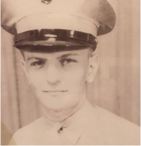 A sepia headshot of a young White man in a uniform looking at the camera.