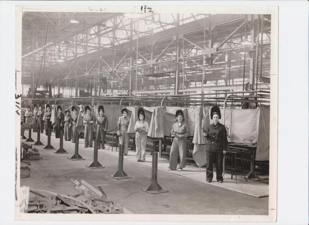 A black and white image of several women welding in a factory.