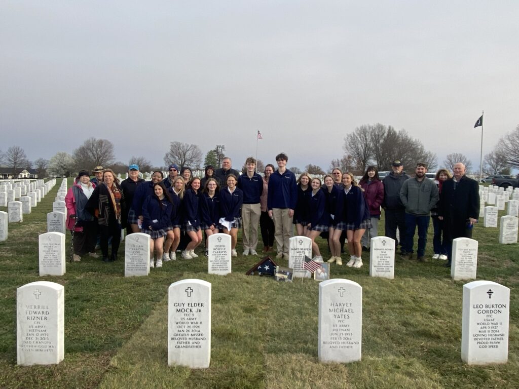 A large group of people standing in a cemetery.