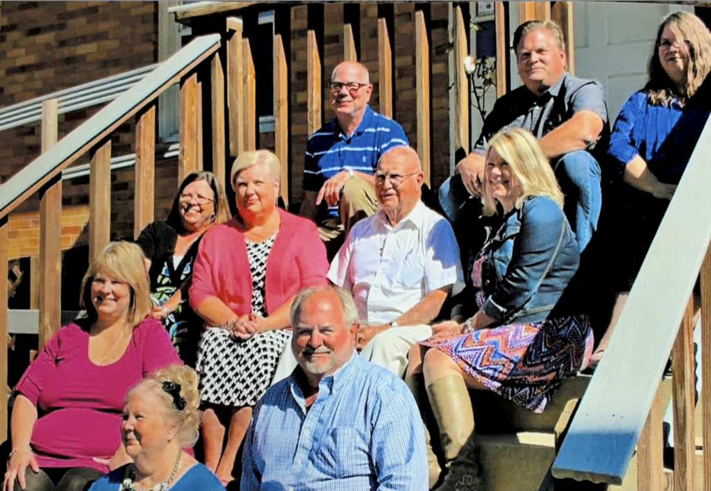 A color photo of several people sitting on stairs. 