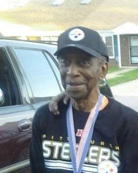 An African American Veteran, wearing a Pittsburgh Steelers hat and shirt with a Congressional Gold Medal.