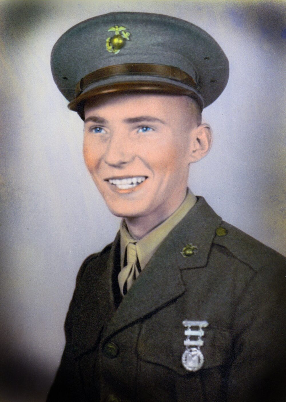A colorized headshot photo of a young White Marine in uniform.