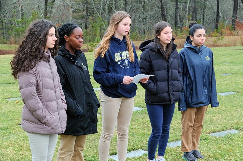 Five students standing in a cemetery.