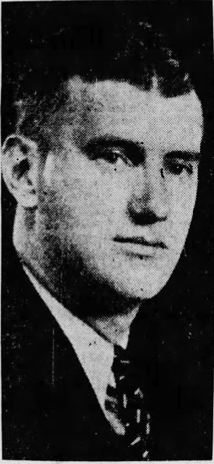 Black and white headshot photo of a young man in a suit and tie.