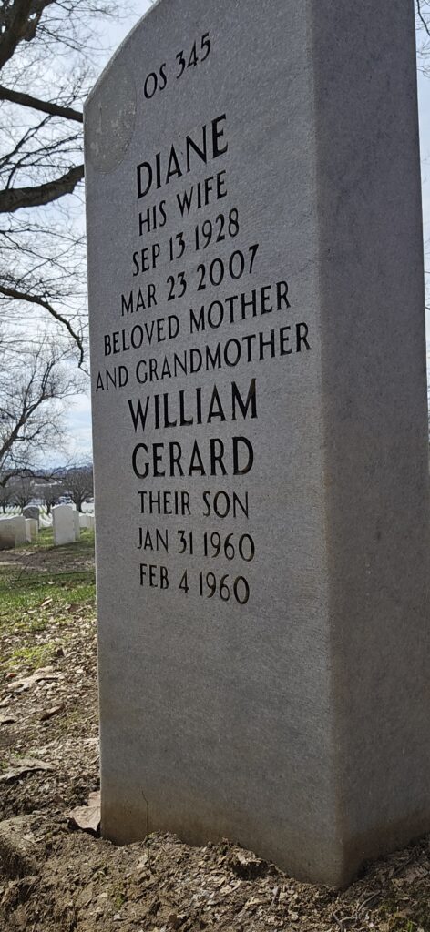 A color image of an arched gray marble headstone engraved with “Diana His wife Sep 13 1928 Mar 23 2007 Beloved Mother and Grandmother William Gerard Their Son Jan 31 1960 Feb 4 1960.”