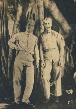 A full-length, sepia image of two young White men in uniforms.