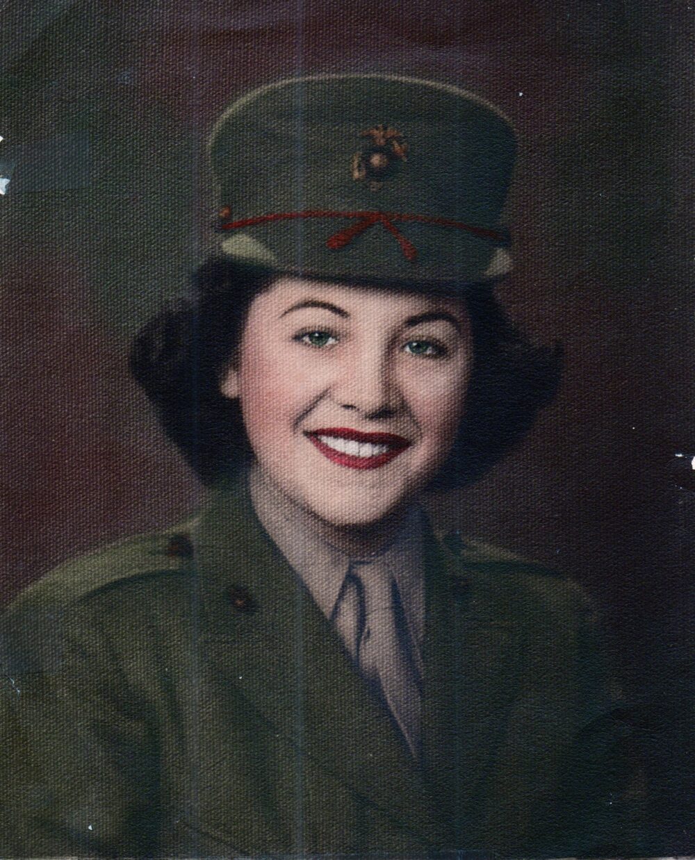 Colorized photo of a young woman in uniform from the chest up.