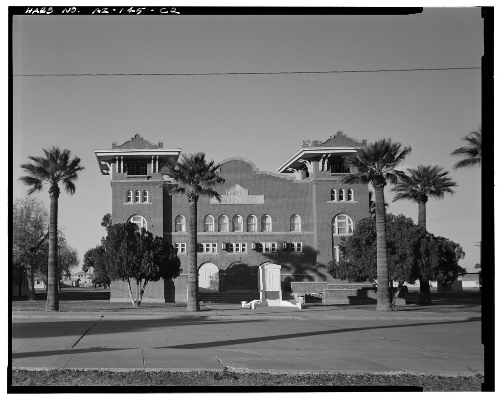 A black and white image of a three-story brick building.