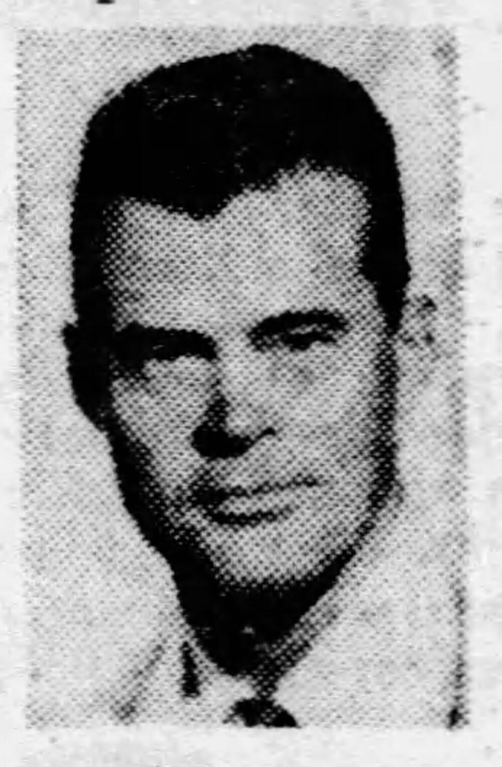 headshot of a White man in a jacket and tie.