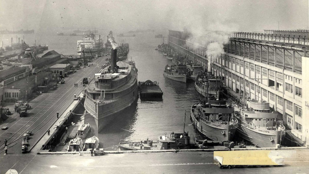 A black and white image of several ships in a port.
