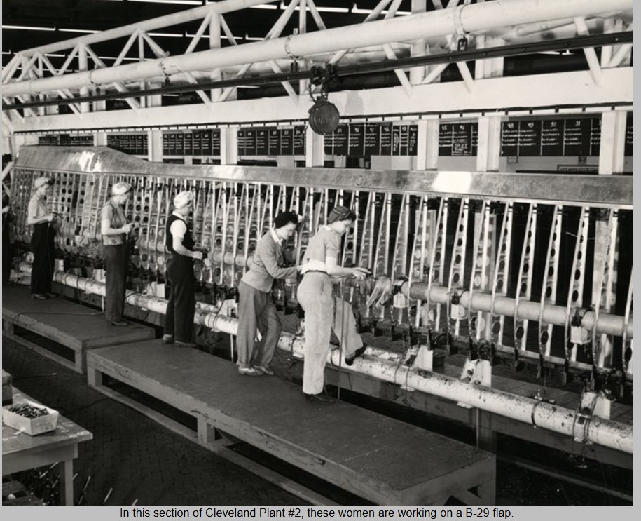 A black and white photograph of women working on a large airplane wing in a factory.